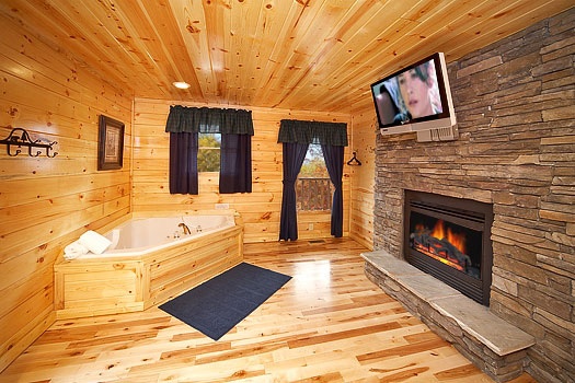 Jacuzzi tub next to fireplace in master bedroom at Big Bear Falls, a 2-bedroom cabin rental located in Gatlinburg