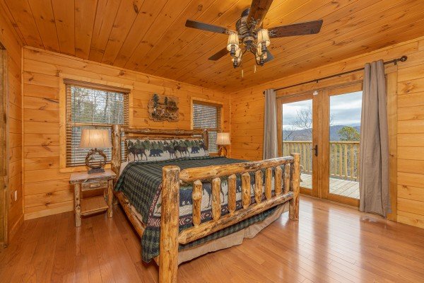 Bedroom with a log bed, two night stands, lamps, and deck access at J's Hideaway, a 4 bedroom cabin rental located in Pigeon Forge