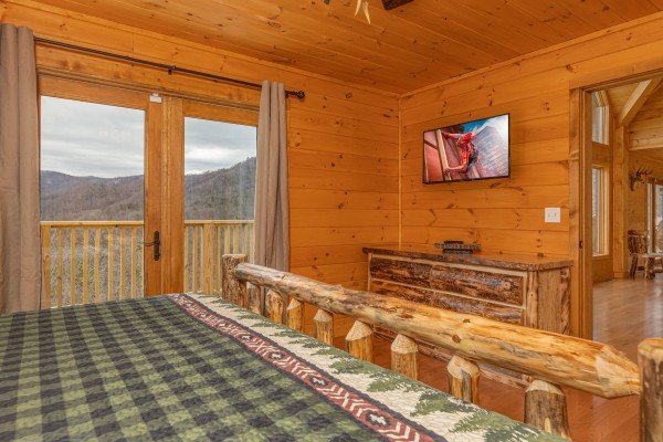Dresser, TV, and deck access in a bedroom at J's Hideaway, a 4 bedroom cabin rental located in Pigeon Forge