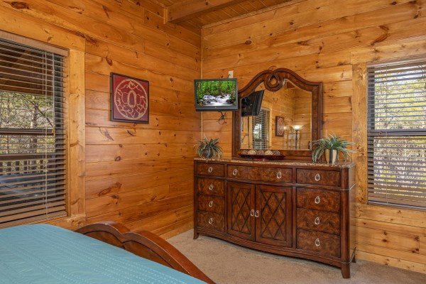Dresser with mirror and a TV in a bedroom at King of the Mountain, a 3 bedroom cabin rental located in Pigeon Forge