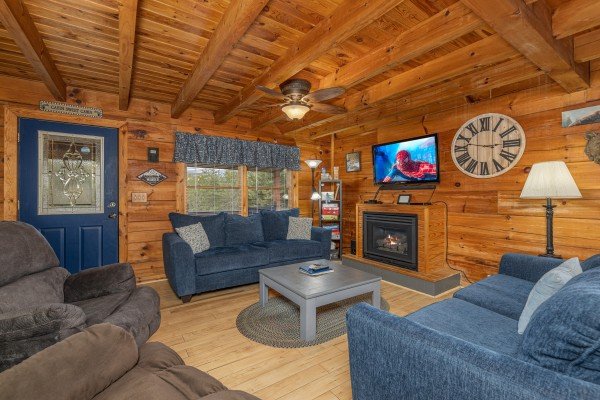 Living room with blue seating at Leconte Nirvana, a 3 bedroom cabin rental located in Pigeon Forge