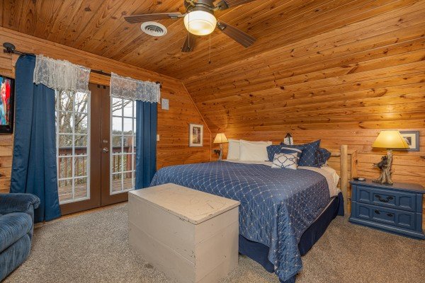 Bedroom with king bed, night stands, lamps, and deck access at Leconte Nirvana, a 3 bedroom cabin rental located in Pigeon Forge