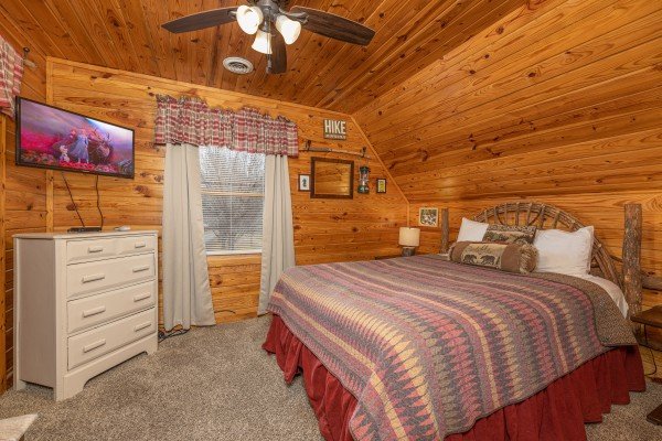 Bedroom with king bed, dresser, and TV at Leconte Nirvana, a 3 bedroom cabin rental located in Pigeon Forge
