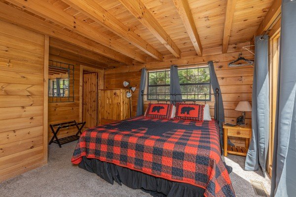 Bedroom with night stand, lamp, and luggage rack at Smoky Mountain High, a 1 bedroom cabin rental located in Pigeon Forge