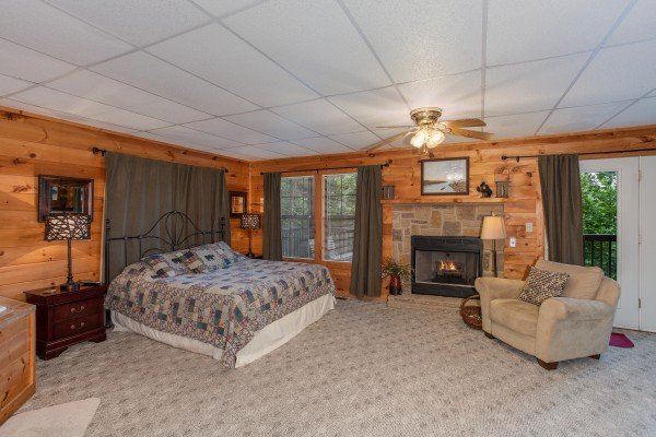 Bedroom with fireplace and chair at A View for You, a 1 bedroom cabin rental located in Pigeon Forge