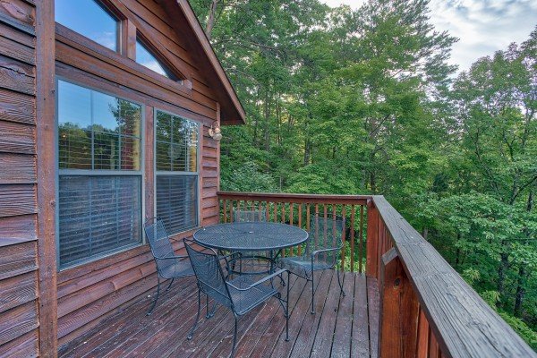Outdoor dining space for four on an open deck at A View for You, a 1 bedroom cabin rental located in Pigeon Forge