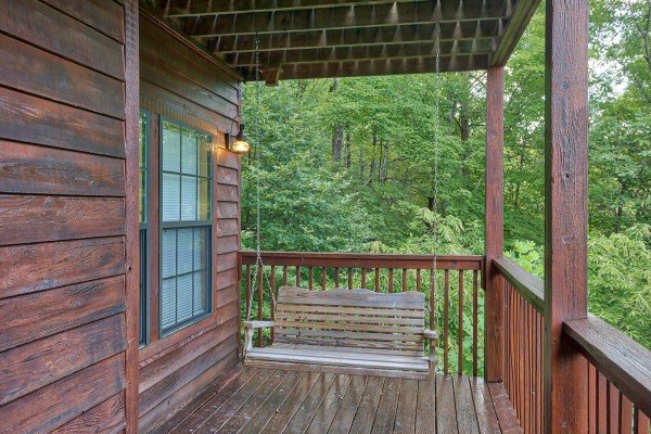 Porch swing on covered deck at A View for You, a 1 bedroom cabin rental located in Pigeon Forge