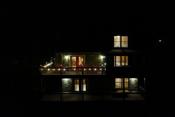 View of rear exterior lit at night at Wonders in the Sky, a 3 bedroom cabin rental located in Gatlinburg
