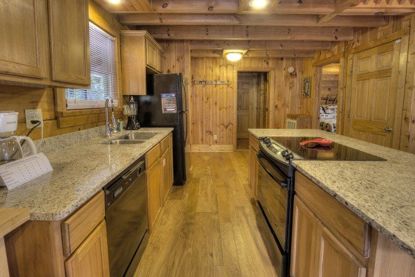 Kitchen with granite counters and black appliances at Wonders in the Sky, a 3 bedroom cabin rental located in Gatlinburg