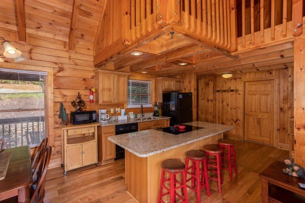 Kitchen with black appliances and counter seating for four at Wonders in the Sky, a 3 bedroom cabin rental located in Gatlinburg