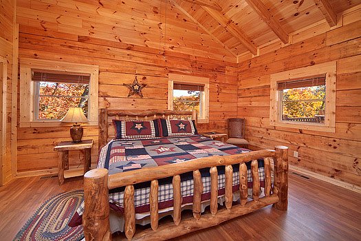 King sized log bed in bedroom at Looky Yonder, a 2 bedroom cabin rental located in Gatlinburg