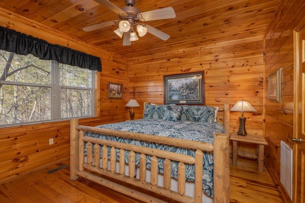 Bedroom with a king bed, two night stands, and two lamps at Hickernut Lodge, a 5-bedroom cabin rental located in Pigeon Forge
