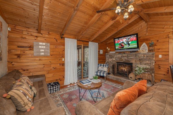 Living room with fireplace and TV at Snuggle Inn, a 2 bedroom cabin rental located in Pigeon Forge