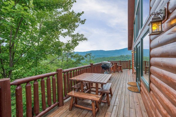 Dining table for four near the grill on the deck at Horse'n Around, a 3 bedroom cabin rental located in Pigeon Forge