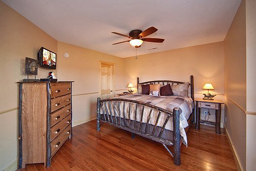 King sized bed with chest of drawers and a TV at Horse'n Around, a 3 bedroom cabin rental located in Pigeon Forge
