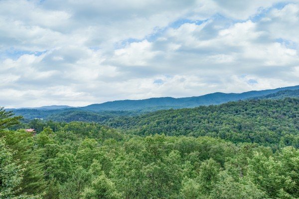 Looking at the verdant Smoky Mountains from the deck at Horse'n Around, a 3 bedroom cabin rental located in Pigeon Forge