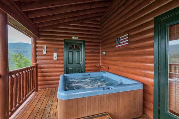 Hot tub on a covered deck facing the mountain views at Horse'n Around, a 3 bedroom cabin rental located in Pigeon Forge