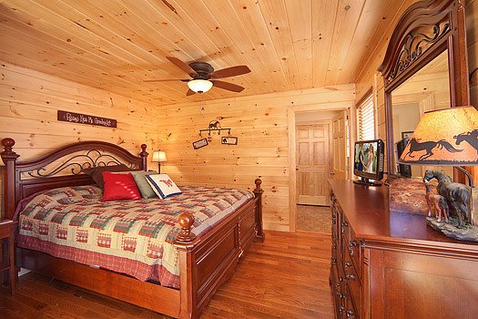 King sized bed in bedroom with en suite at Horse'n Around, a 3 bedroom cabin rental located in Pigeon Forge