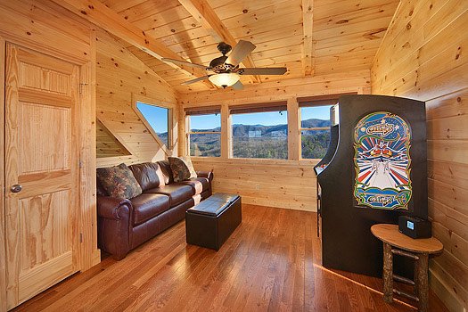 Sofa bed across from arcade in lofted game room at Horse'n Around, a 3 bedroom cabin rental located in Pigeon Forge