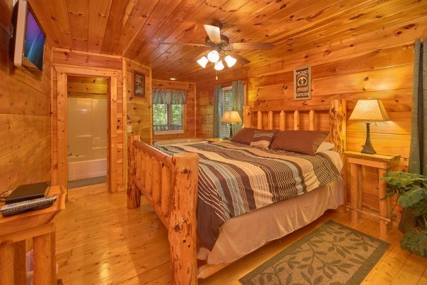Bedroom with king bed, TV, and en suite bath at Pop's Snuggle Bear, a 1 bedroom cabin rental located in Pigeon Forge 