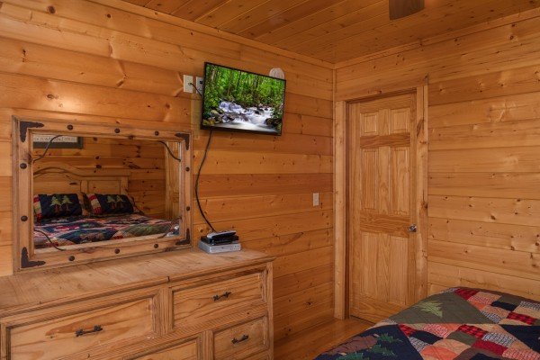 Dresser, mirror, and TV in a bedroom Kick Back & Relax! A 4 bedroom cabin rental located in Pigeon Forge