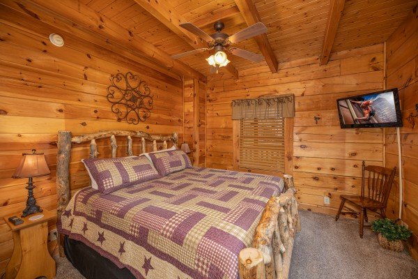 Bedroom with bed, night stands, lamps, and TV at Livin' Simple, a 2 bedroom cabin rental located in Pigeon Forge 