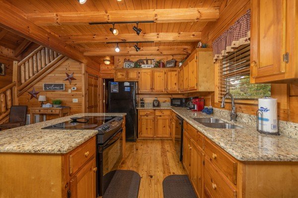 Galley kitchen with black appliances and granite counters at Livin' Simple, a 2 bedroom cabin rental located in Pigeon Forge
