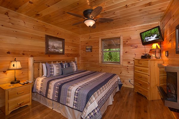 Bedroom with a king bed, fireplace, and TV at Rustic Romance, a 2 bedroom cabin rental located in Pigeon Forge