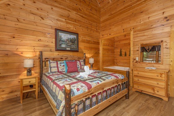 Bedroom with a king bed, night stands, dresser, and jacuzzi at Location Location Location, a 1 bedroom cabin rental located in Pigeon Forge