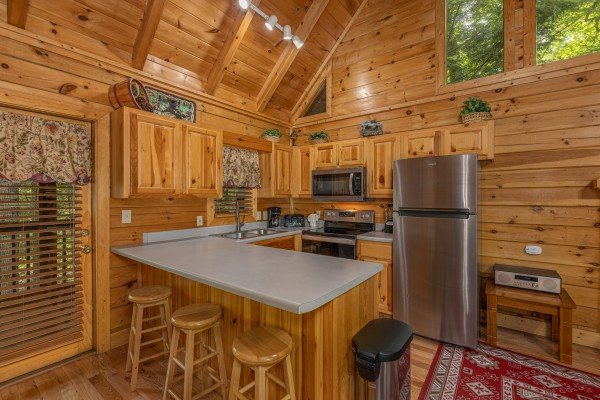 Kitchen with stainless steel appliances and a breakfast bar at Location Location Location, a 1 bedroom cabin rental located in Pigeon Forge
