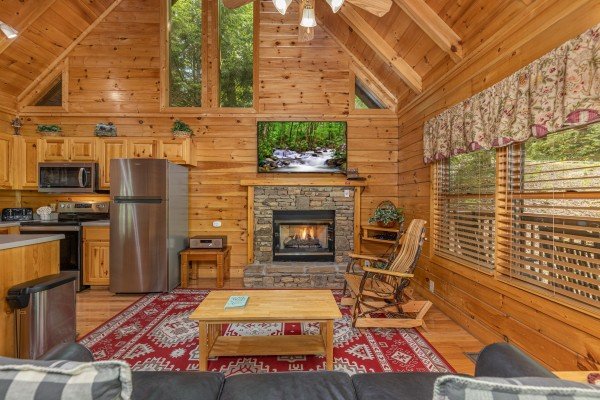 Living room with a fireplace and TV at Location Location Location, a 1 bedroom cabin rental located in Pigeon Forge