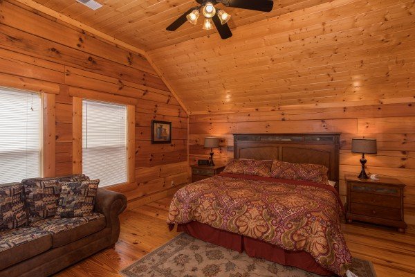 Bedroom with night stands, lamps, and a sleeper sofa at Pigeon Forge View, a 6 bedroom cabin rental located in Pigeon Forge