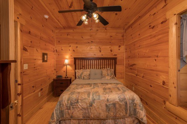 Bedroom with a bed, night stand, and lamp at Pigeon Forge View, a 6 bedroom cabin rental located in Pigeon Forge