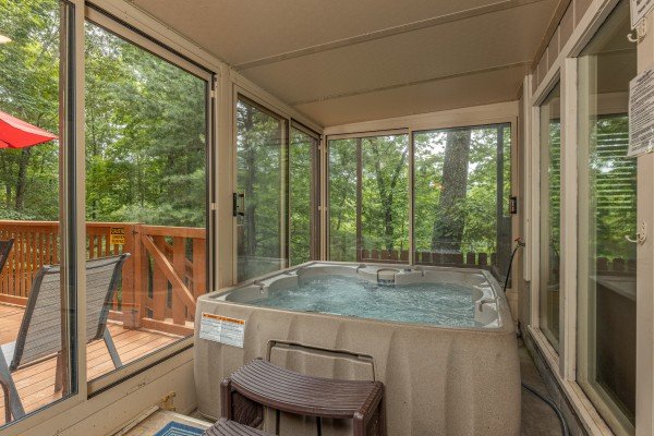 Hot tub on  screened in porch at Buena Vista Getaway, 3 bedroom cabin rental located in Gatlinburg