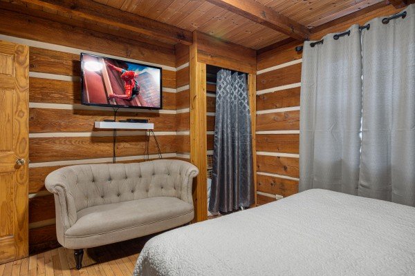 Bedroom bench and flat screen at Henwood's Hideaway, a 1 bedroom cabin rental located in Pigeon Forge
