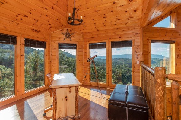 Loft space with a desk and telescope at Four Seasons Palace, a 5-bedroom cabin rental located in Pigeon Forge