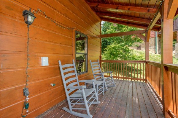 Rocking chairs on a covered porch at Pinot Paradise, a 3 bedroom cabin rental located in Pigeon Forge