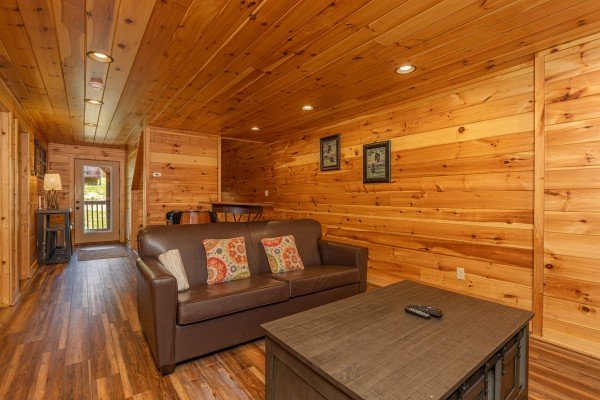 Sofa in the theater room at Pinot Paradise, a 3 bedroom cabin rental located in Pigeon Forge
