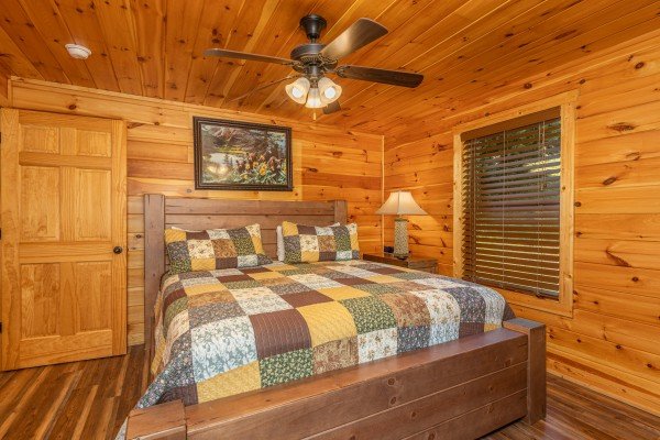 Bedroom with a queen bed, night stand, and lamp at Pinot Paradise, a 3 bedroom cabin rental located in Pigeon Forge