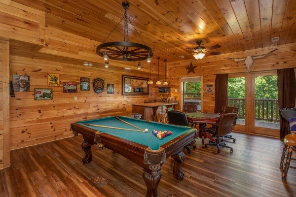 Game room with a green felt pool table and poker table at God's Country, a 4 bedroom cabin rental located in Pigeon Forge