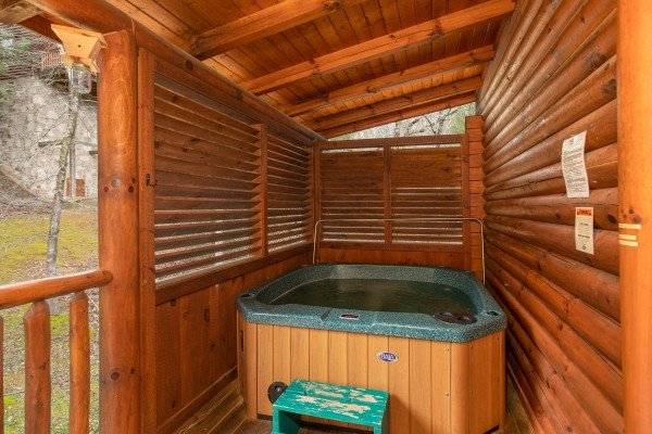 Hot tub on a covered deck with privacy fence at Let the Good Times Roll, a 2 bedroom cabin rental located in Pigeon Forge