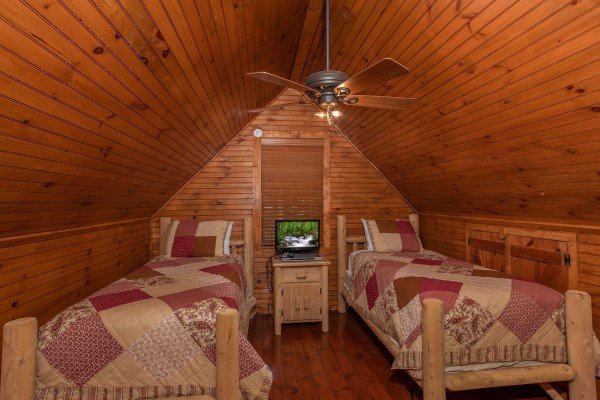 Two twin beds in the loft space at Golden Memories, a 1-bedroom cabin rental located in Pigeon Forge