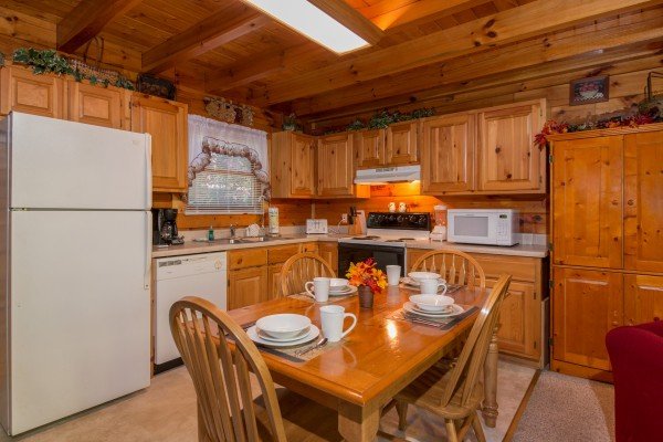 Kitchen with white appliances and dining space for 4 at A Honeymoon Haven, a 1 bedroom cabin rental located in Gatlinburg