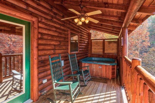 Deck with rocking chairs and hot tub at 5 Little Cubs, a 2 bedroom cabin rental located in Pigeon Forge