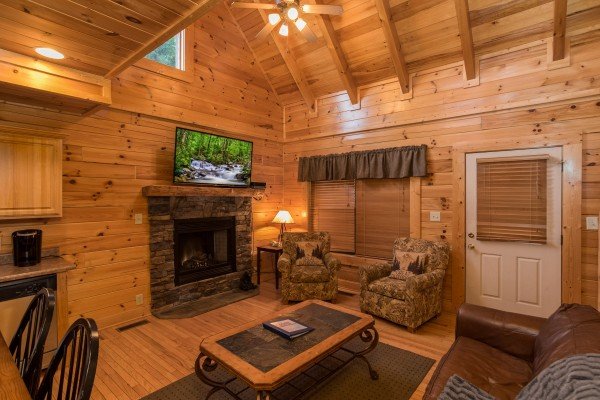 Living room with fireplace and TV at 5 Little Cubs, a 2 bedroom cabin rental located in Pigeon Forge