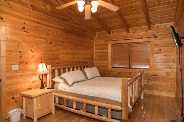 Log bed, night stand, and lamp at 5 Little Cubs, a 2 bedroom cabin rental located in Pigeon Forge
