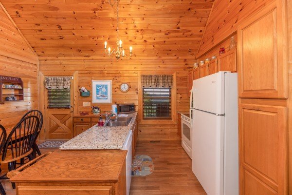Kitchen with white appliances and breakfast bar at Grand View, a 3 bedroom cabin rental located in Sevierville