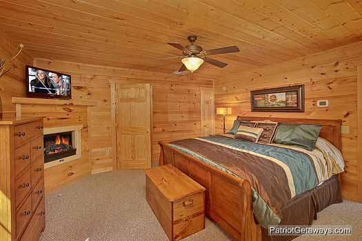 First floor bedroom Alpine Pointe, a 5 bedroom cabin rental located in Gatlinburg with a fireplace tv and attached bathroom with jacuzzi tub