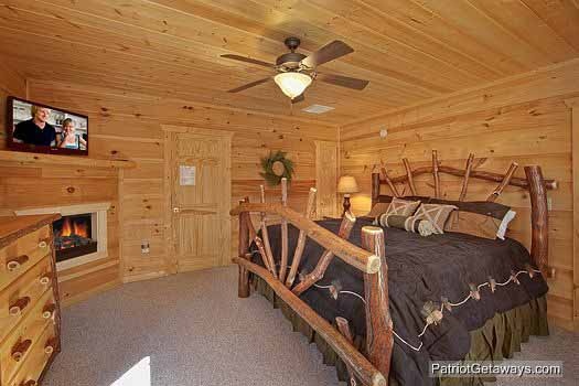 Third floor bedroom with king sized bed fireplace tv and attached bathroom at Alpine Pointe, a 5 bedroom cabin rental located in Gatlinburg