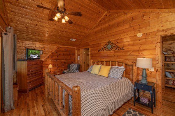 Loft bedroom with a log bed, night stand and lamp, dresser, and TV at Majestic Mountain, a 4 bedroom cabin rental located in Pigeon Forge